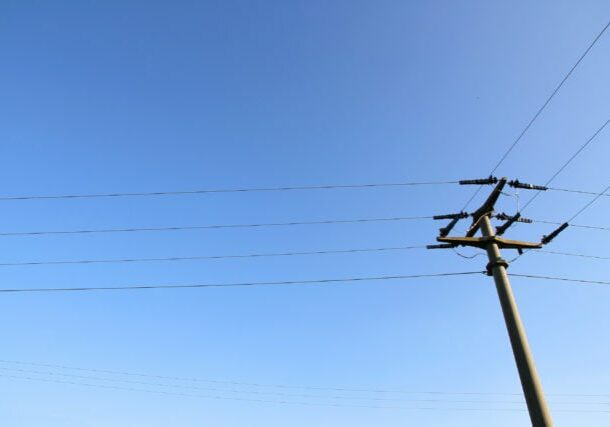 Power lines in front of a blue sky.