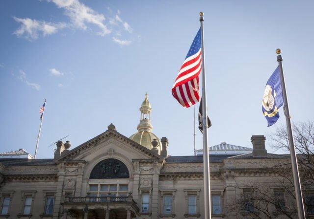 TRENTON, NJ - APRIL 4, 2015: The American Flag flying in front of the New Jersey State House located in Trenton. The capitol building for the state of New Jersey is located on State St.