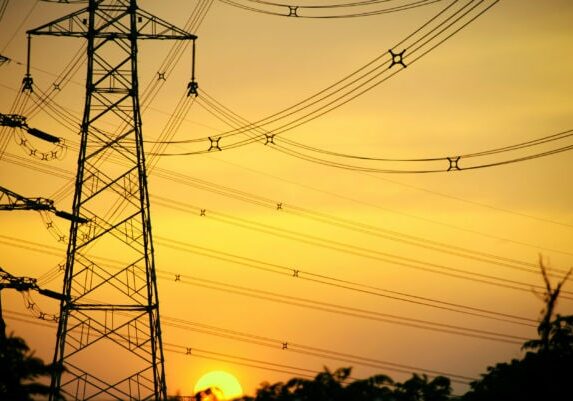 Sun setting behind a row of electricity pylons